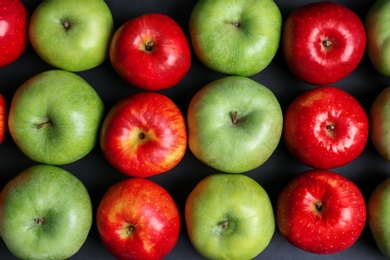 Photo of Fresh green and red apples on dark background, top view