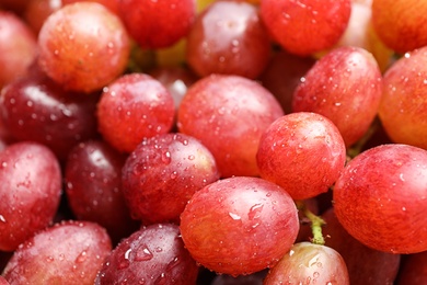 Photo of Fresh ripe juicy pink grapes as background, closeup view