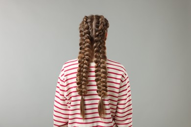 Photo of Woman with braided hair on grey background, back view