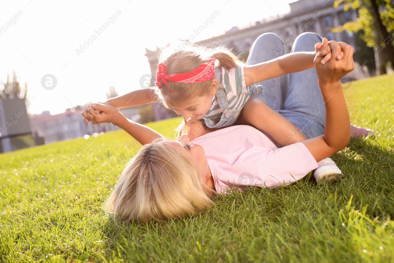 Photo of Happy mother and her child having fun on green grass. Spending time in nature