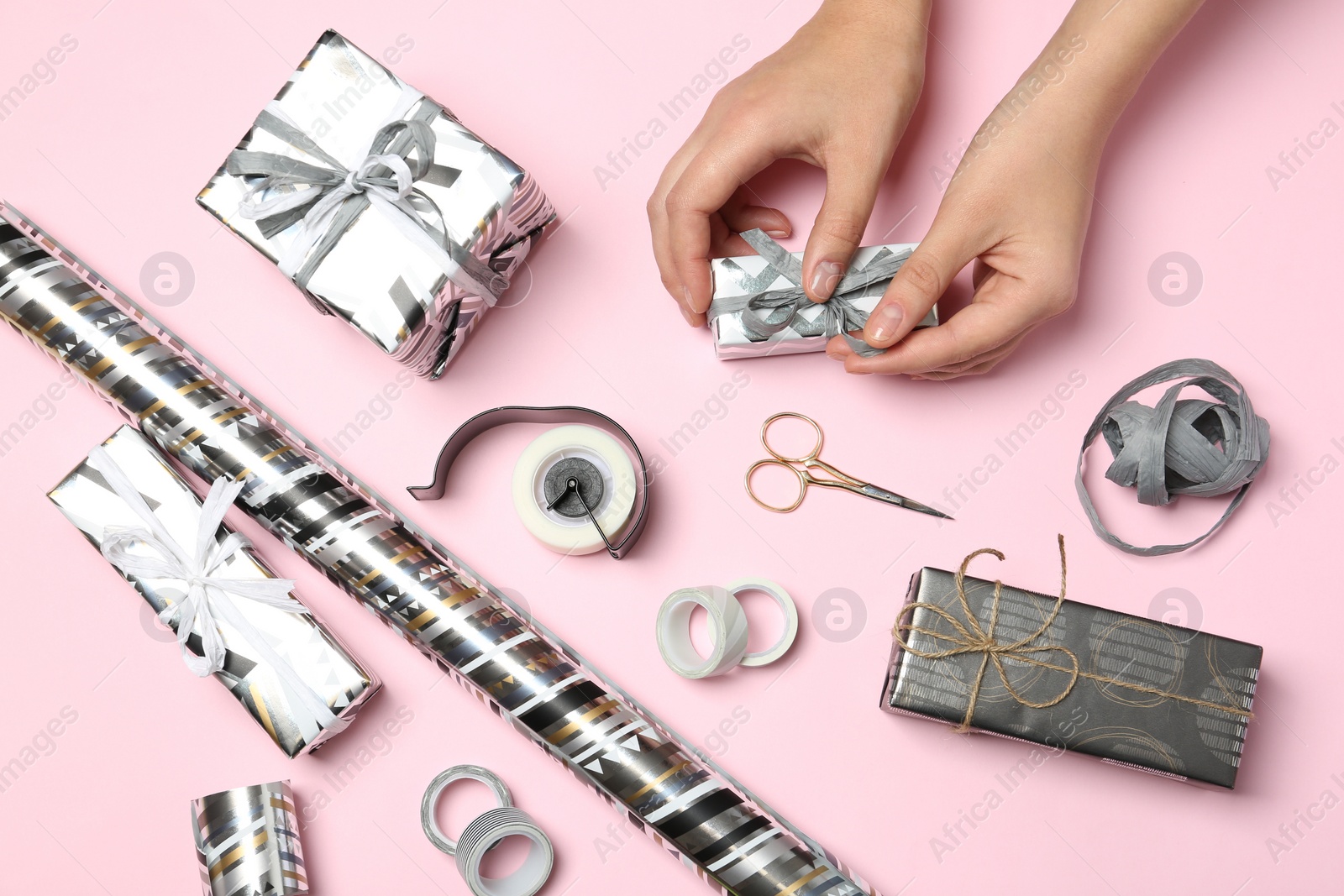 Photo of Woman decorating gift box on color background, top view