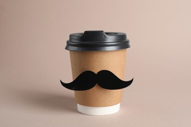 Photo of Paper cup of drink with fake mustache on grey background