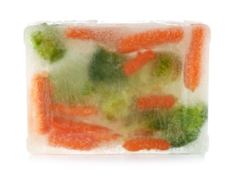 Photo of Fresh vegetables frozen in ice cube on white background