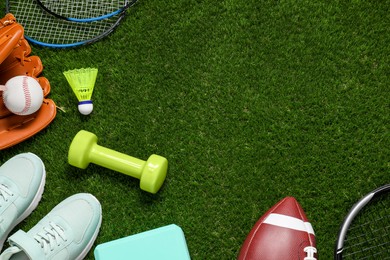 Photo of Different sport tools on green grass, flat lay. Space for text