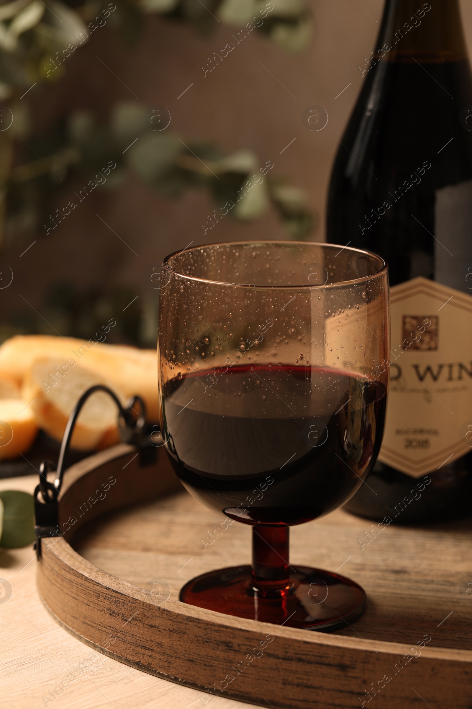 Photo of Glass of tasty red wine on wooden table