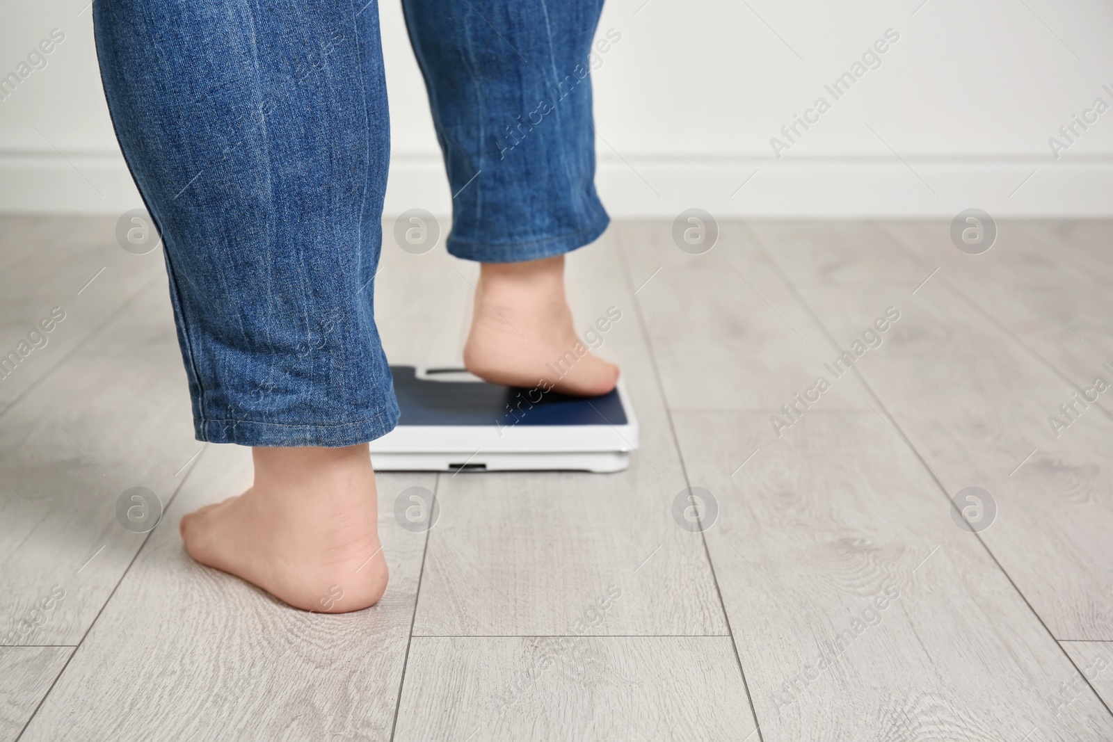 Photo of Overweight woman using scales indoors