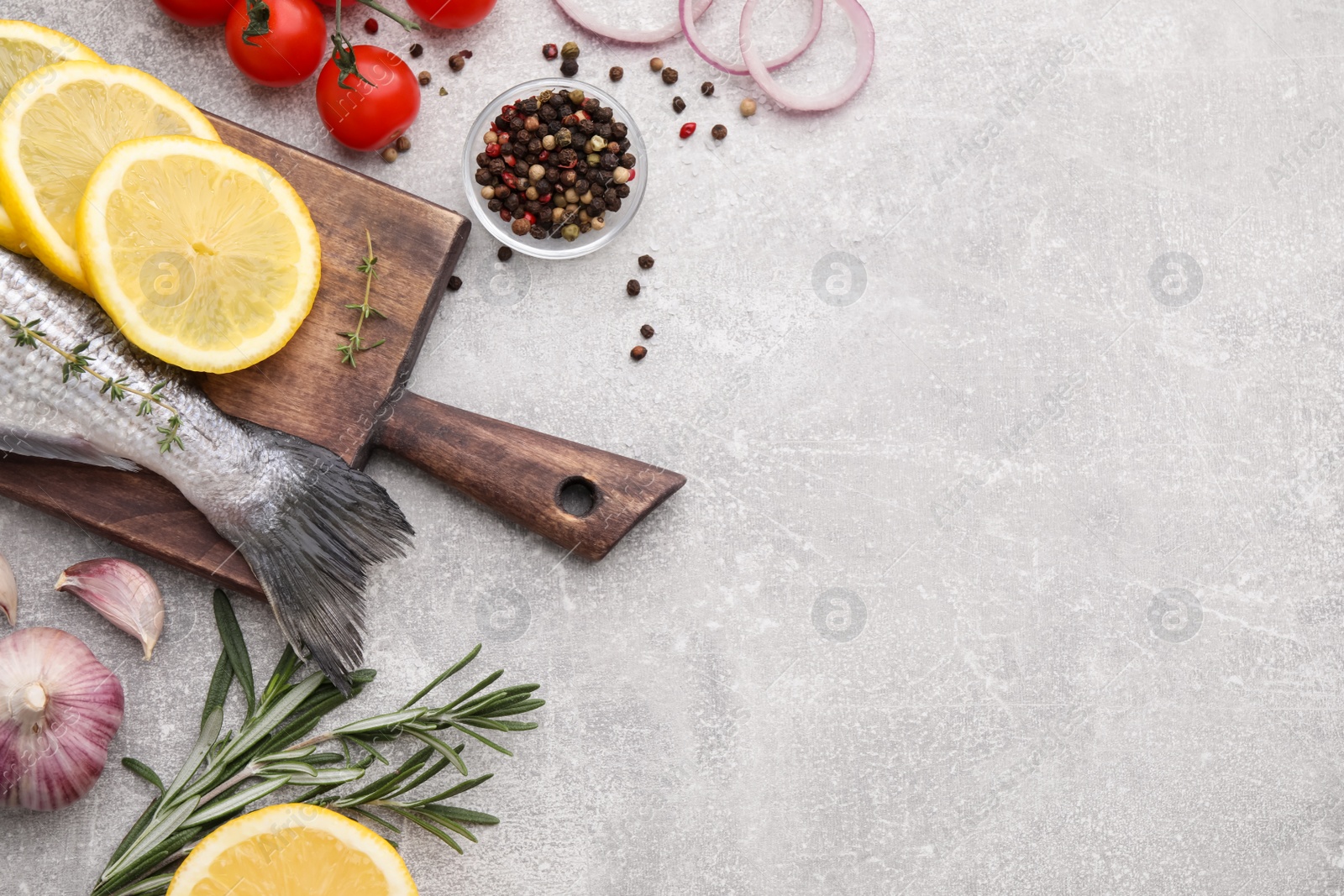 Photo of Flat lay composition with fresh raw dorado fish and ingredients on light grey table, space for text