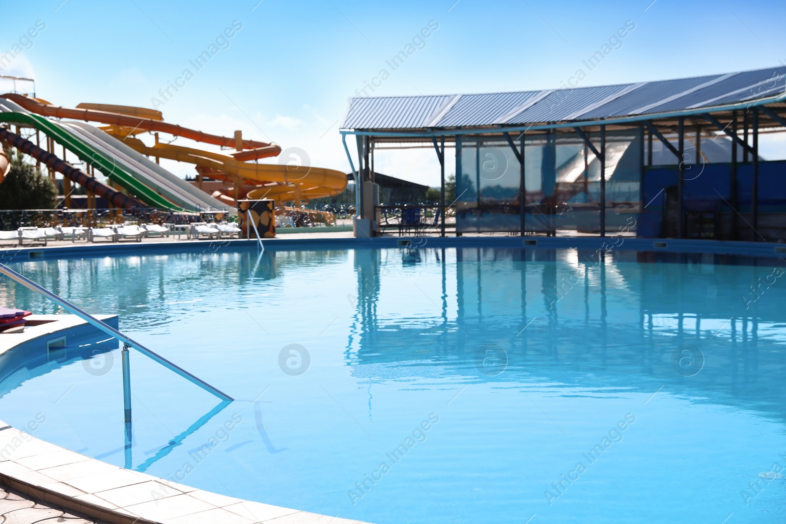 Photo of Outdoor swimming pool with clear water on sunny day. Summer vacation