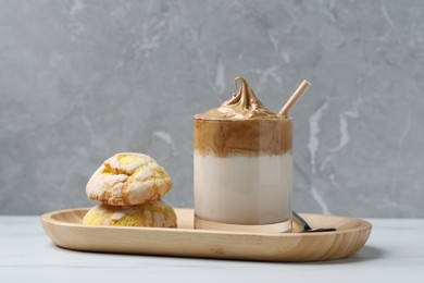 Photo of Glass of delicious dalgona coffee and cookies on white marble table