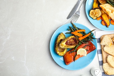 Delicious cooked salmon and vegetables served on grey table, flat lay with space for text. Healthy meals from air fryer