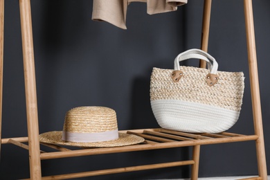 Photo of Straw hat and bag on clothing rack indoors