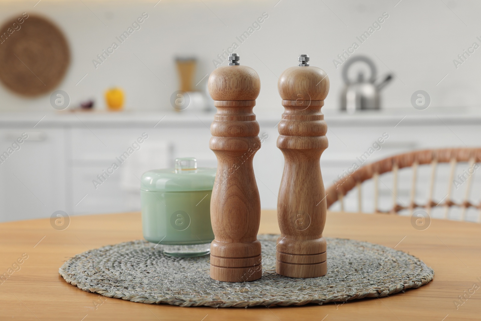 Photo of Wooden salt and pepper shakers on table in kitchen, space for text