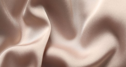 Texture of beige crumpled silk fabric as background, top view