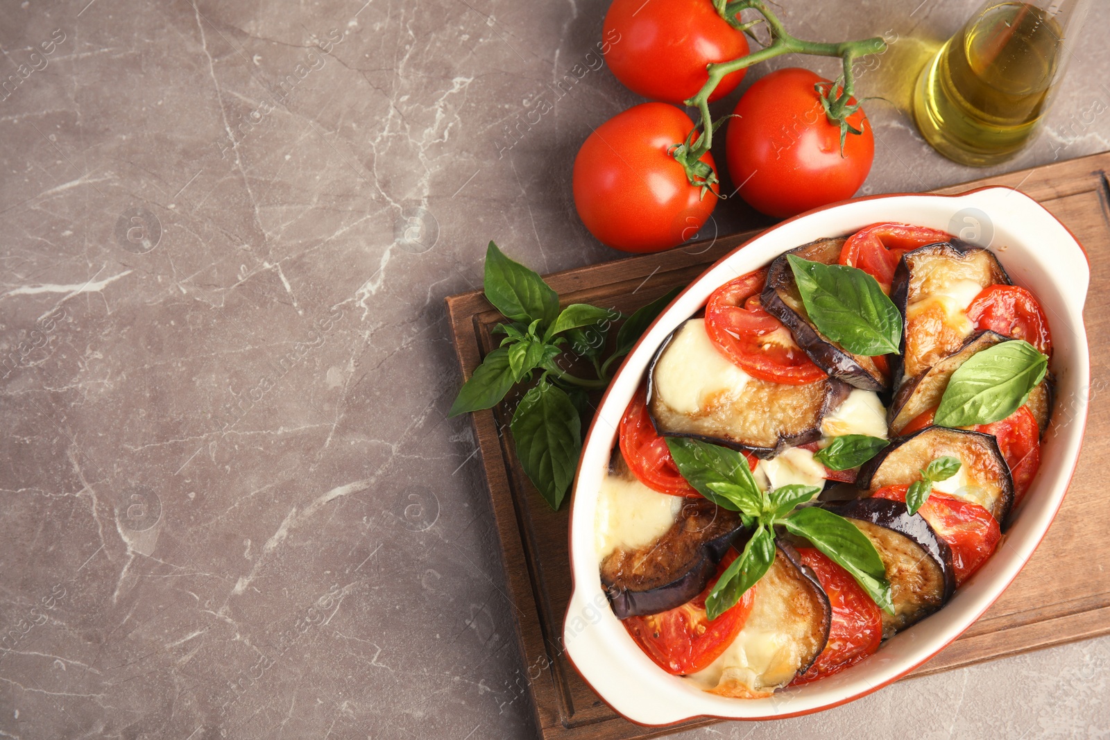 Photo of Flat lay composition with baked eggplant, tomatoes and basil in dishware on table. Space for text