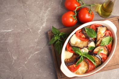 Photo of Flat lay composition with baked eggplant, tomatoes and basil in dishware on table. Space for text