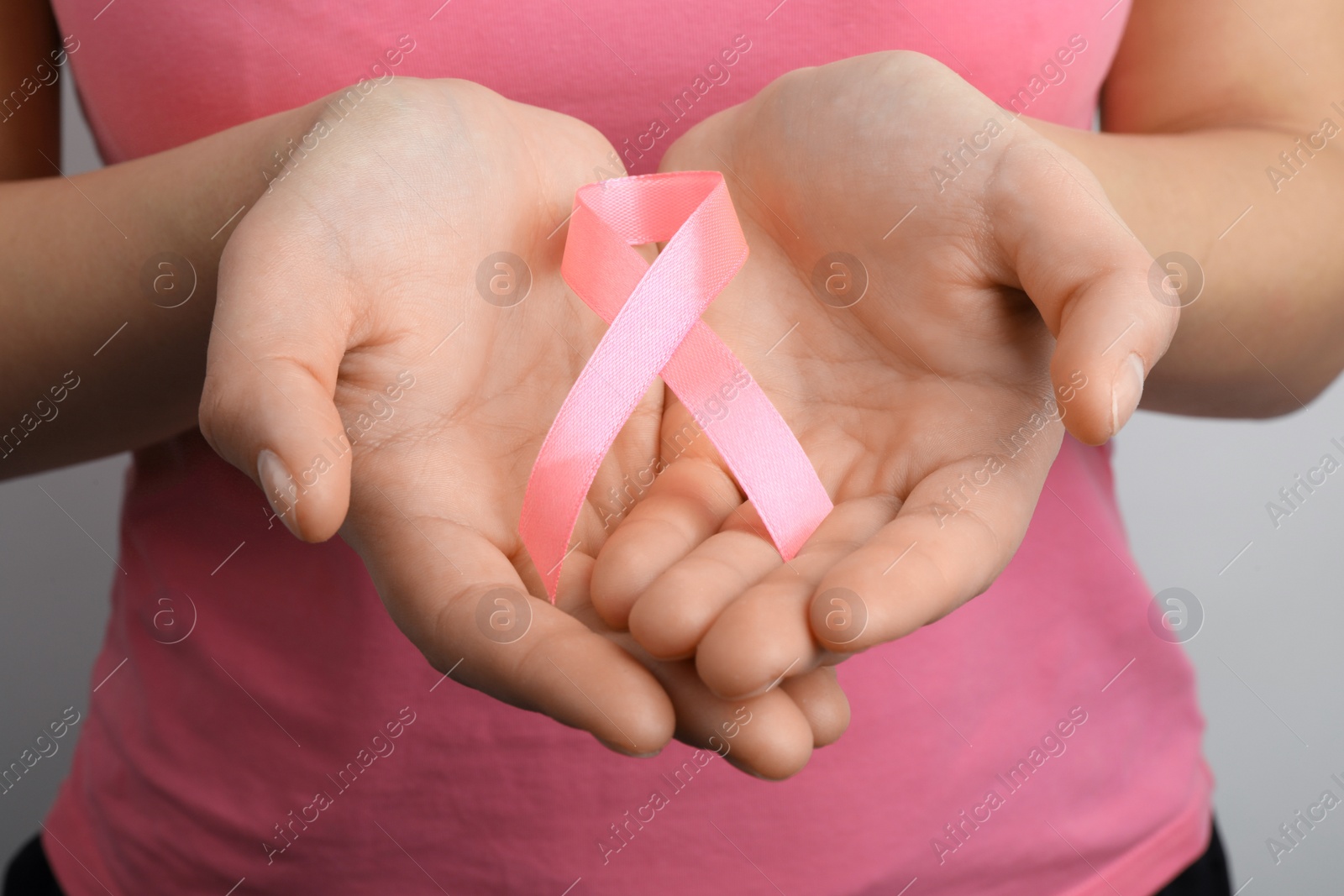 Photo of Woman holding pink ribbon, closeup. Breast cancer awareness