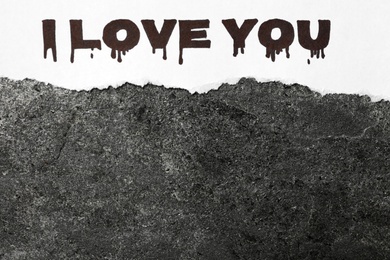Torn sheet of paper with words I Love You on grey stone background, top view. Space for text