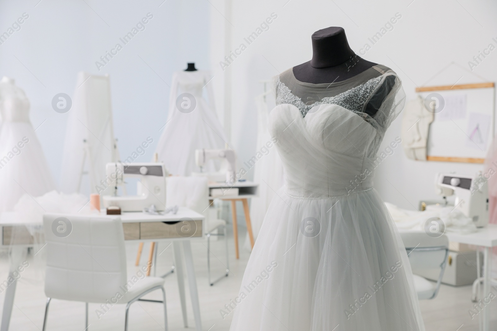 Photo of Mannequin with beautiful wedding dress in atelier. Space for text