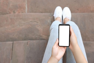 Photo of Closeup of woman using smartphone outdoors, top view. Space for text