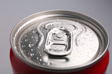 Photo of Energy drink in wet can on light grey background, closeup