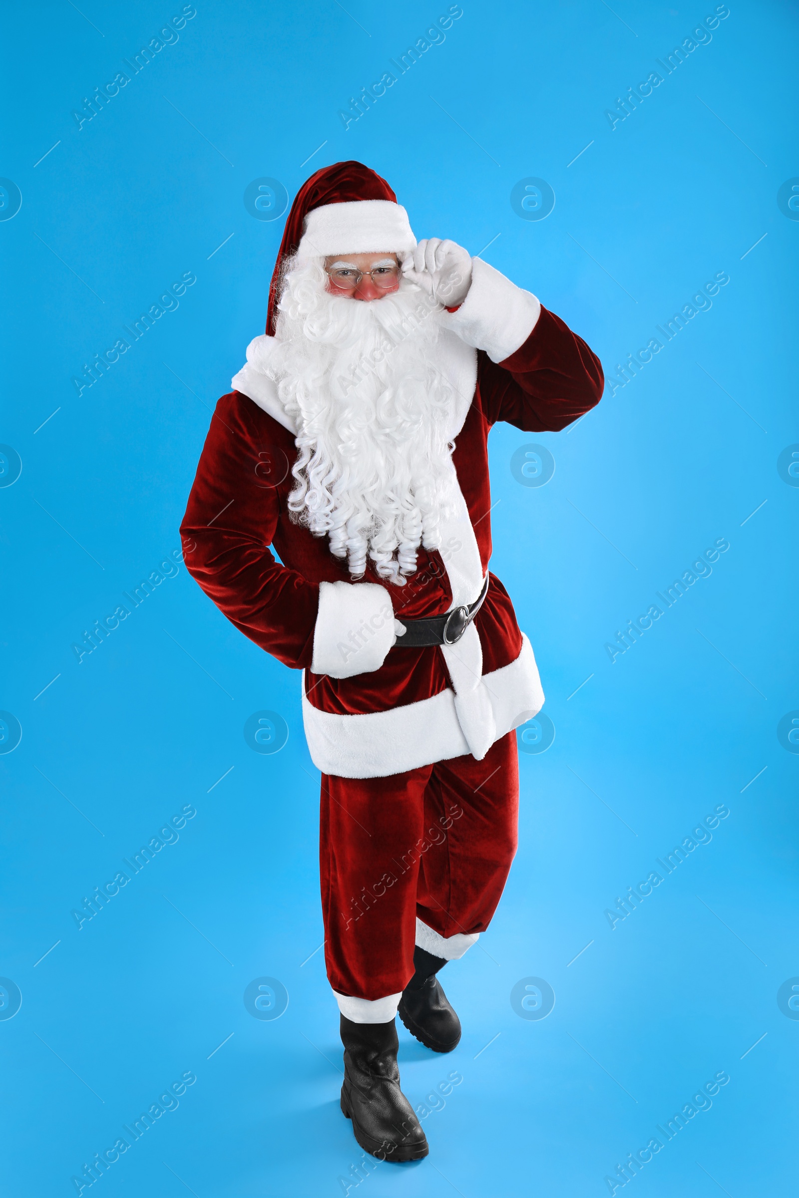 Photo of Full length portrait of Santa Claus on light blue background