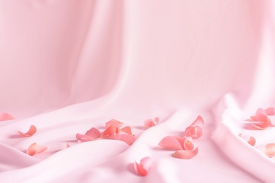 Photo of Beautiful rose petals on soft pink fabric