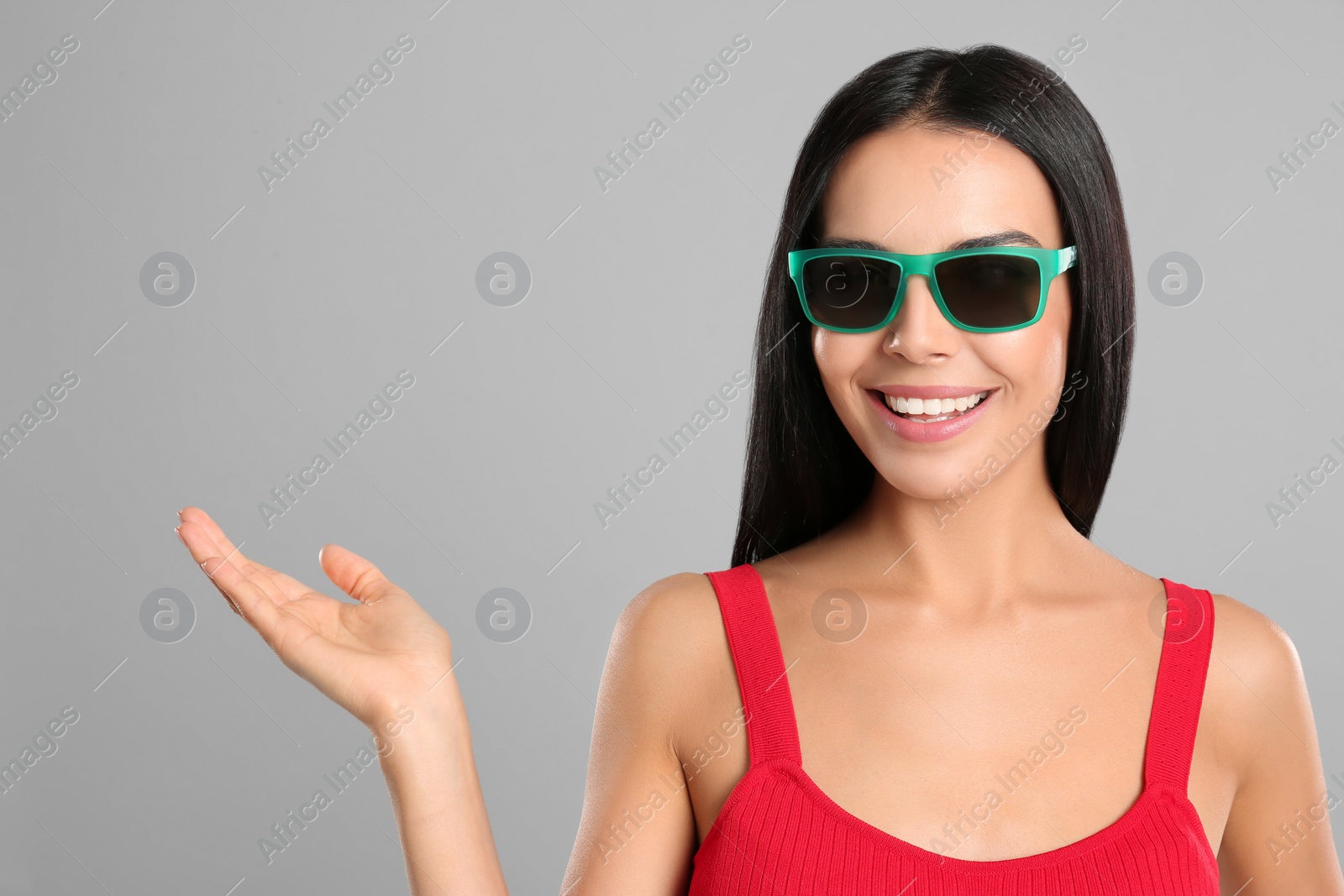 Photo of Beautiful woman wearing sunglasses on grey background