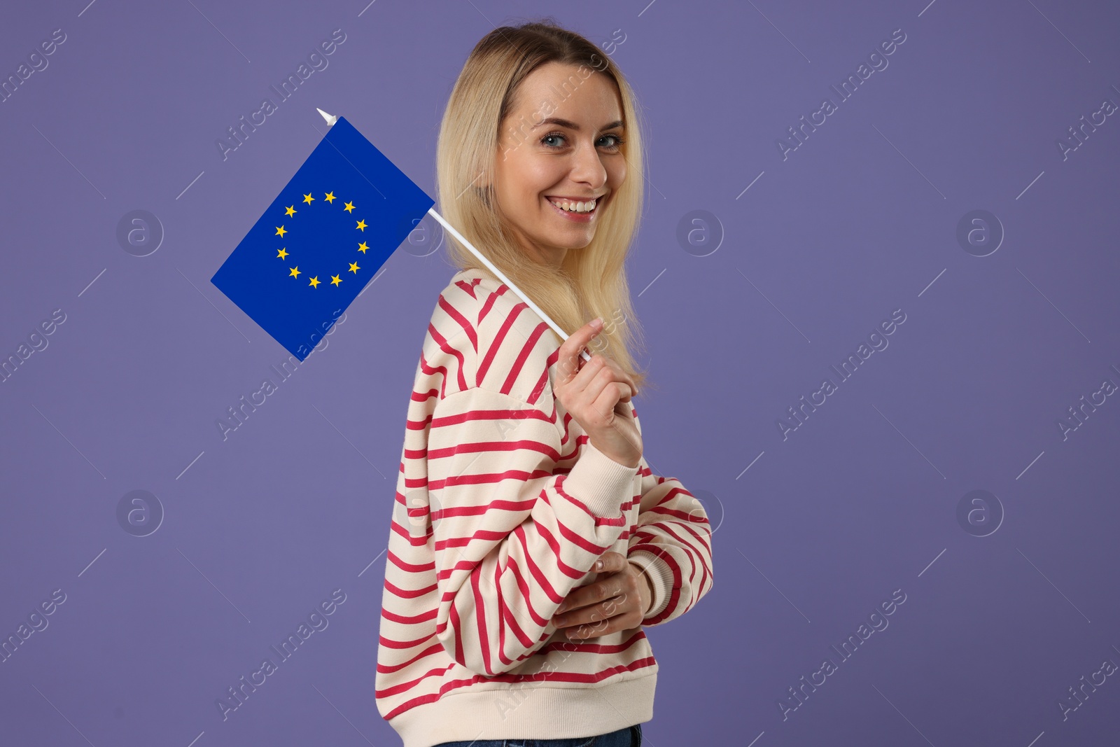 Image of Happy young woman with flag of European Union on purple background