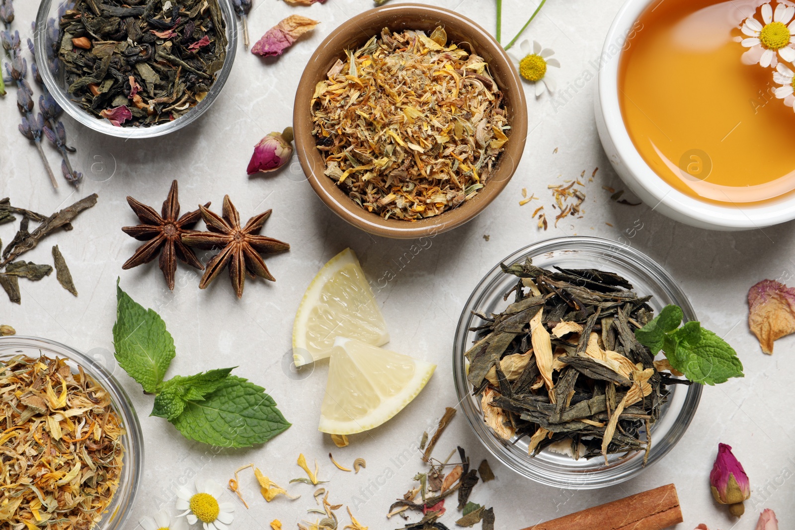 Photo of Flat lay composition with fresh brewed tea and dry leaves on light table