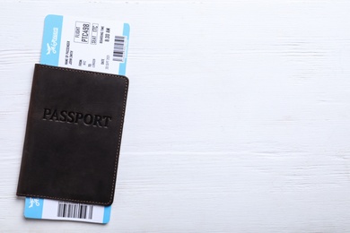 Photo of Passport with ticket on white wooden table, top view and space for text. Travel agency concept