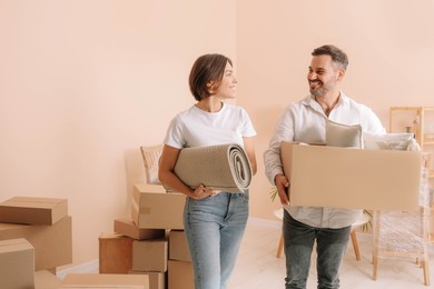 Photo of Happy couple with stuff in new apartment. Moving day