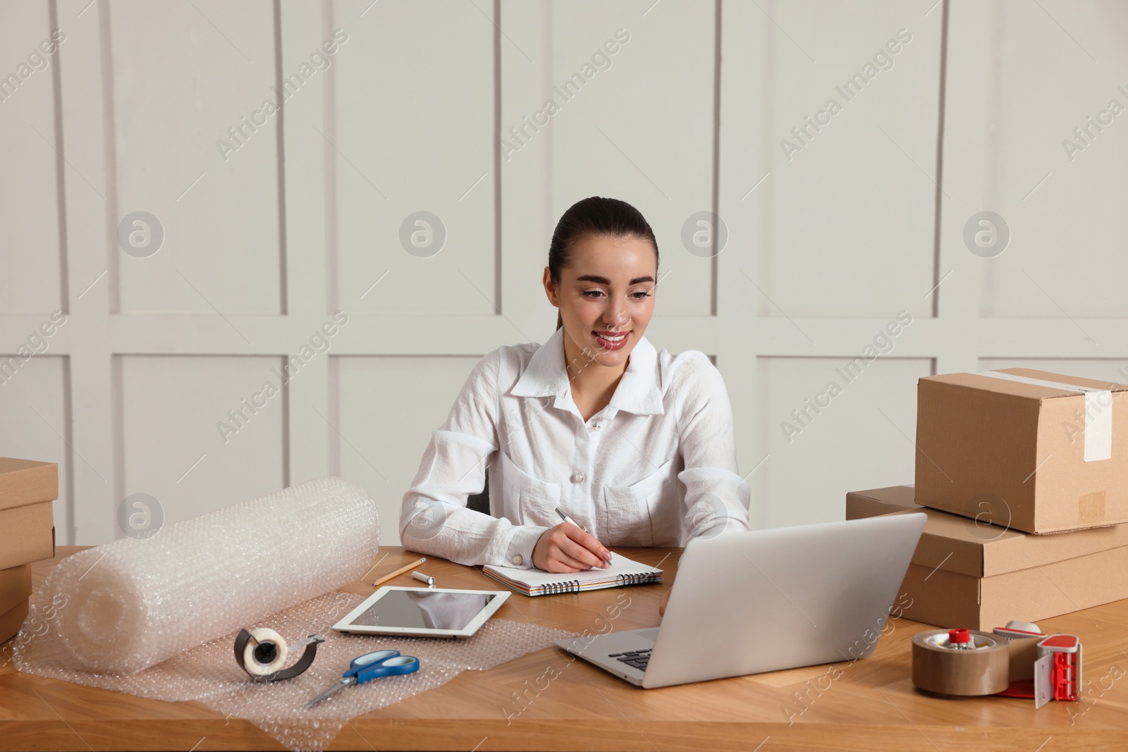 Photo of Seller working with laptop at table in office. Online store