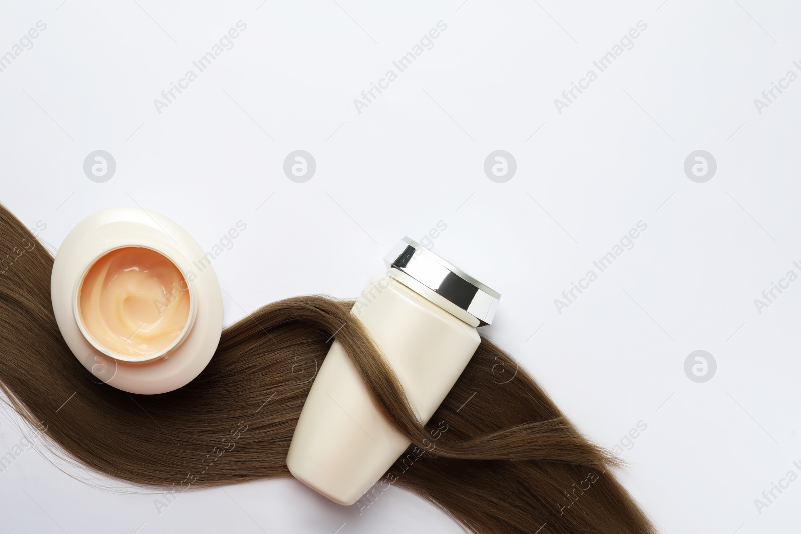 Photo of Natural cosmetic products and hair lock on white background, flat lay. Space for text