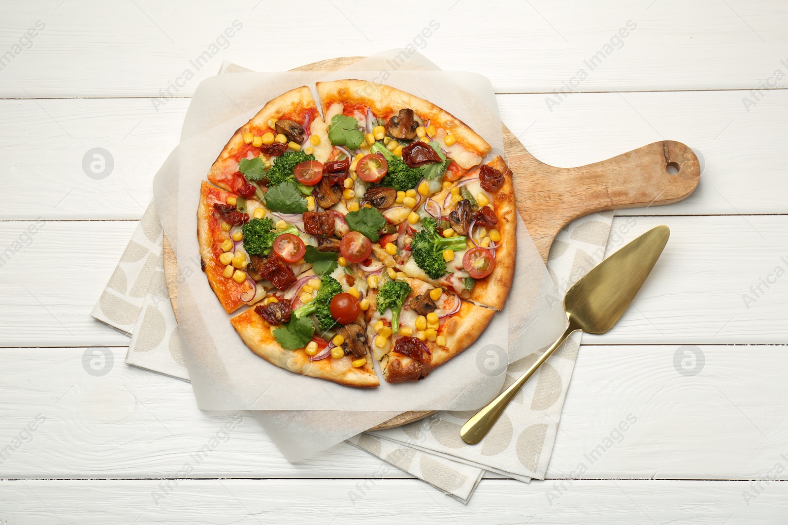 Photo of Delicious vegetarian pizza and server on white wooden table, top view