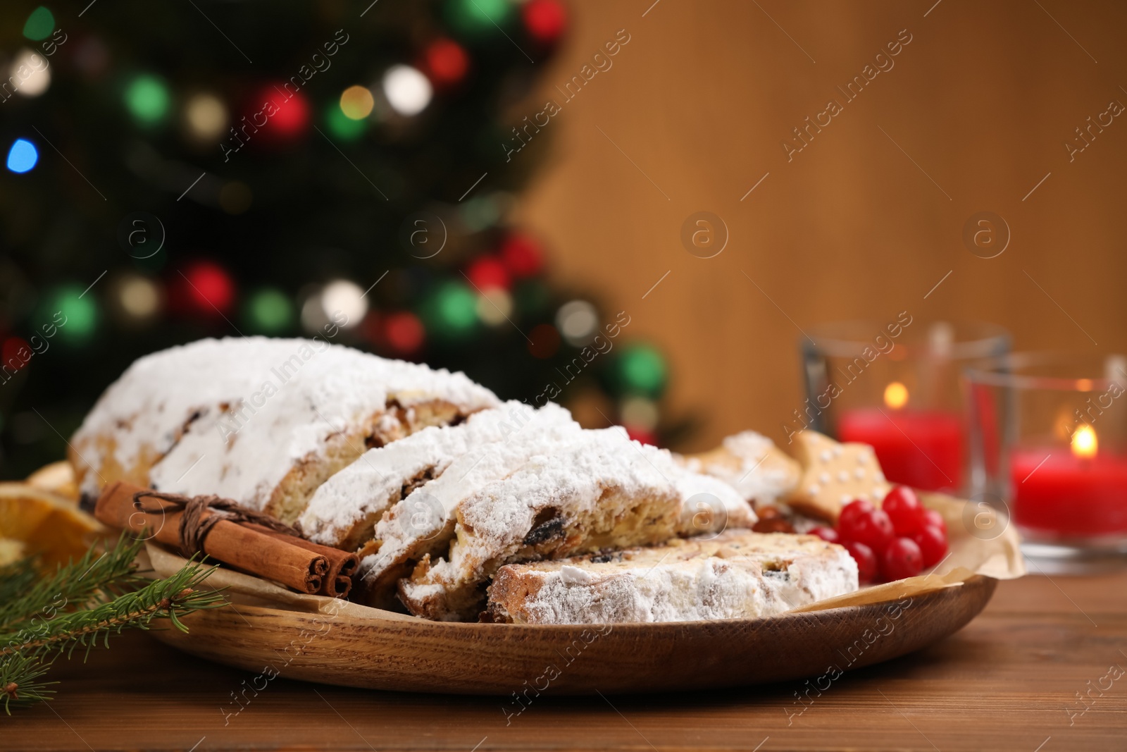 Photo of Traditional Christmas Stollen with icing sugar on wooden table