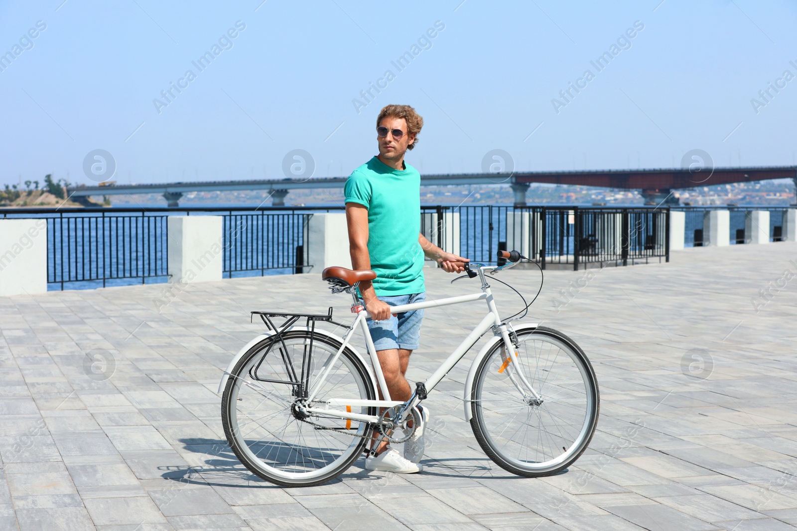 Photo of Handsome young man with bicycle outdoors on sunny day