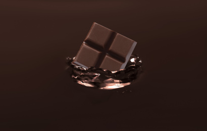 Yummy melted chocolate with falling pieces as background