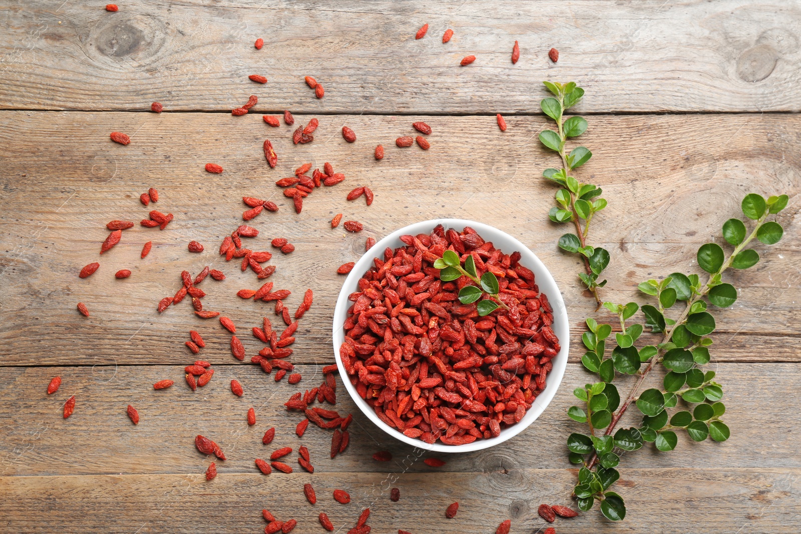 Photo of Flat lay composition with dried goji berries on wooden table. Healthy superfood