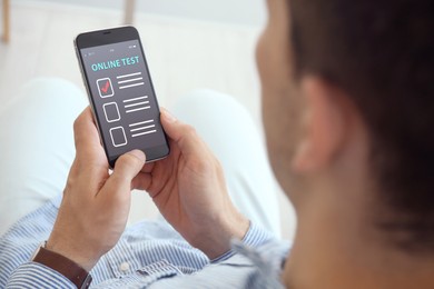 Image of Man using smartphone for online test indoors, closeup