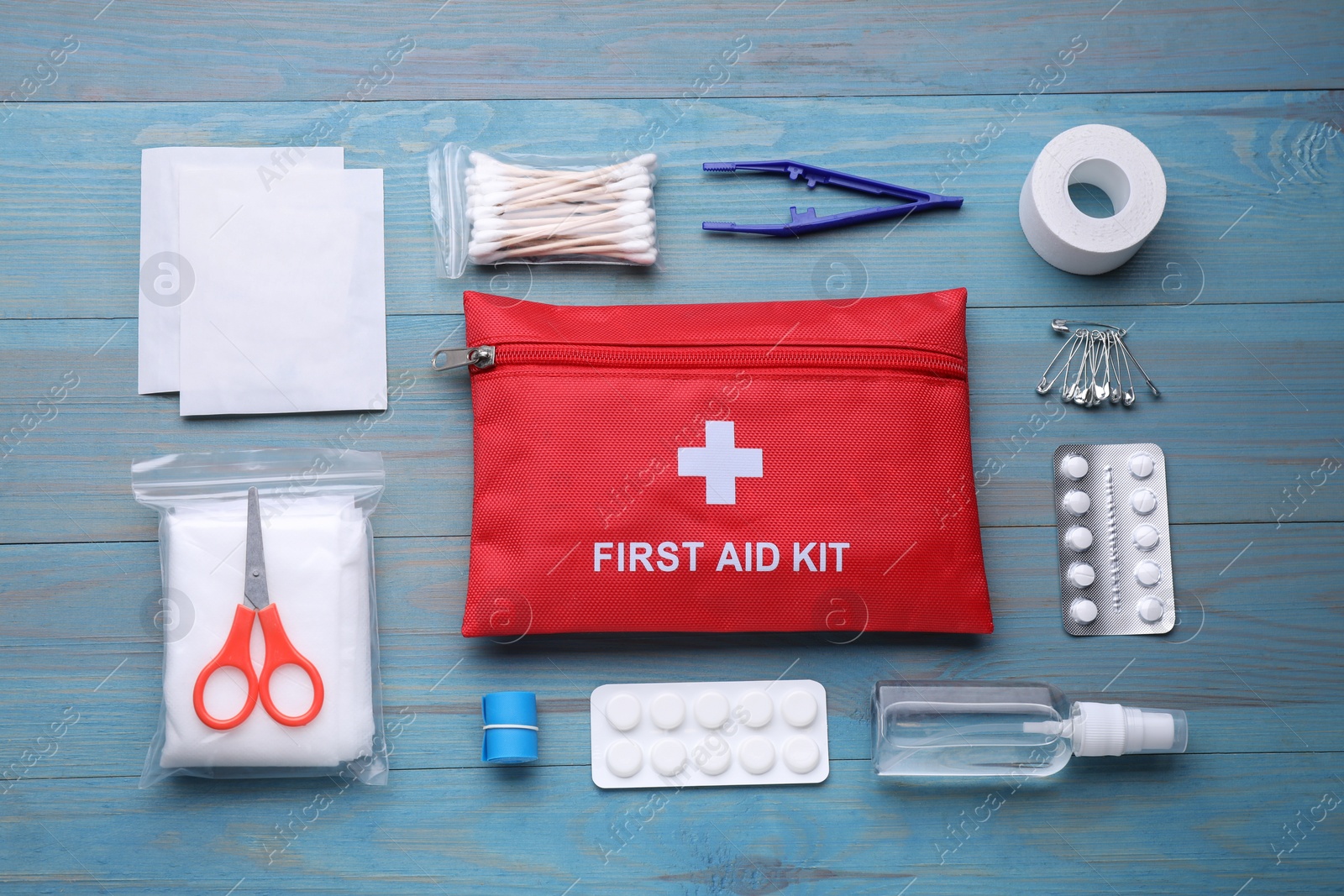 Photo of Flat lay composition with first aid kit on blue wooden table