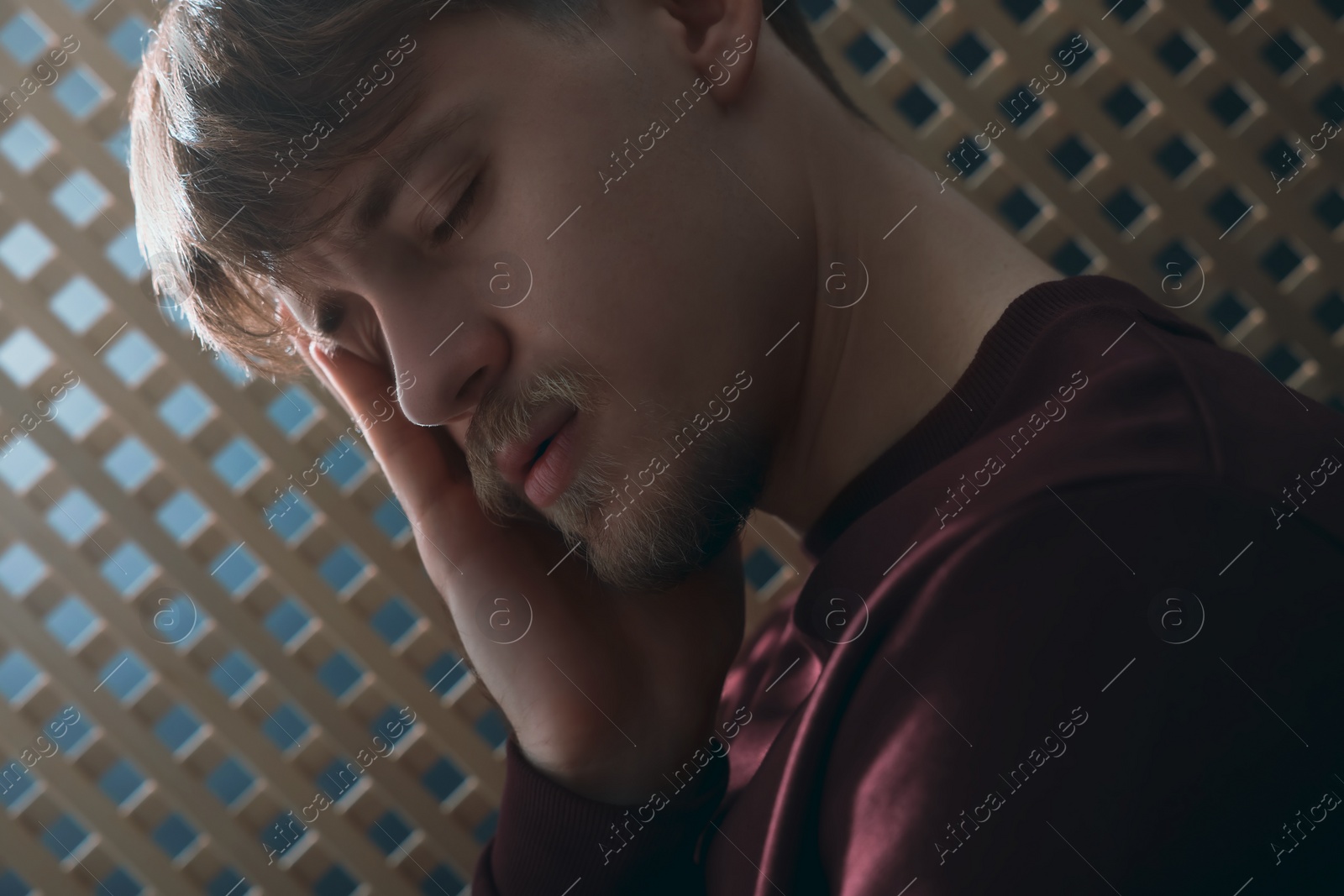 Photo of Upset young man during confession in booth, closeup