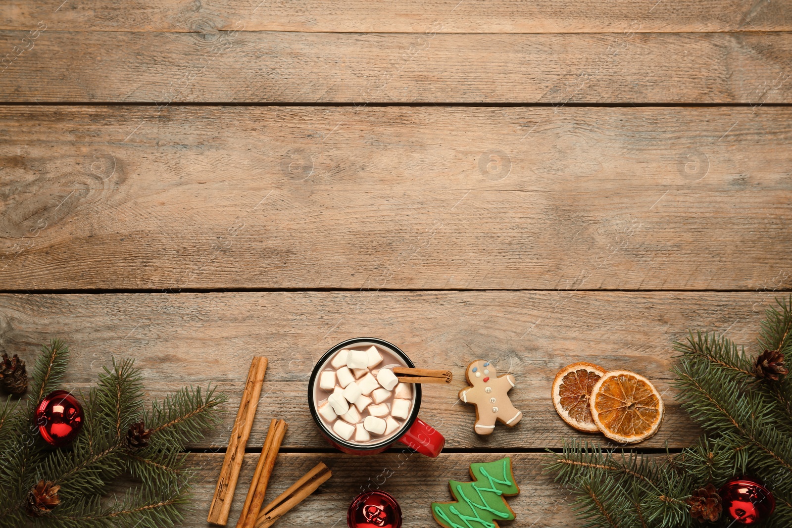 Photo of Flat lay composition of delicious hot chocolate with marshmallows and Christmas decor on wooden table, space for text