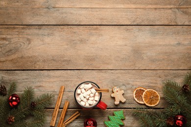 Photo of Flat lay composition of delicious hot chocolate with marshmallows and Christmas decor on wooden table, space for text