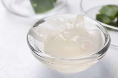 Photo of Aloe vera gel in bowl on white background, closeup