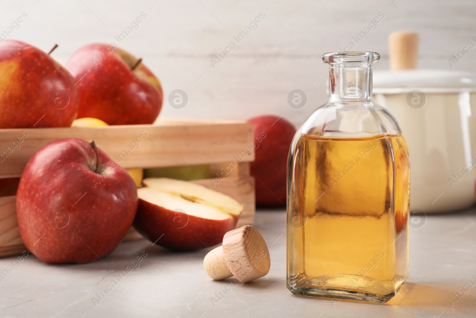 Photo of Composition with bottle of apple vinegar on table. Space for text