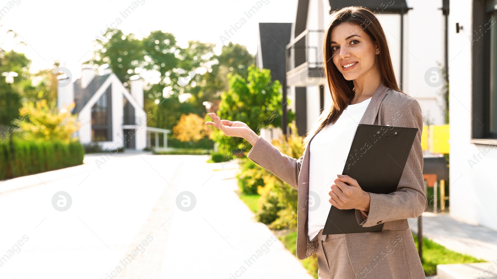 Photo of Beautiful real estate agent with documents outdoors