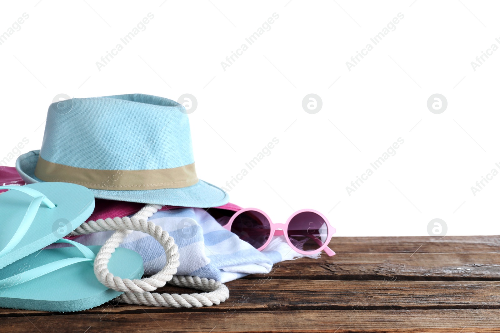 Photo of Different beach objects on wooden table against white background. Space for text