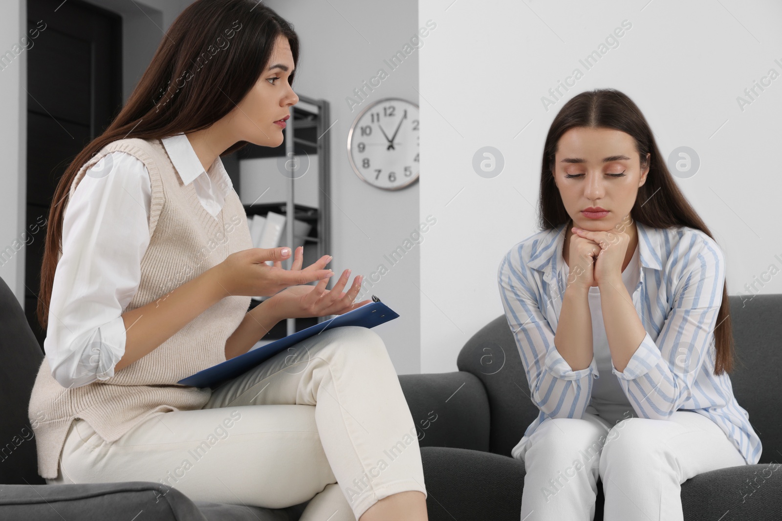 Photo of Professional psychologist working with young woman in office