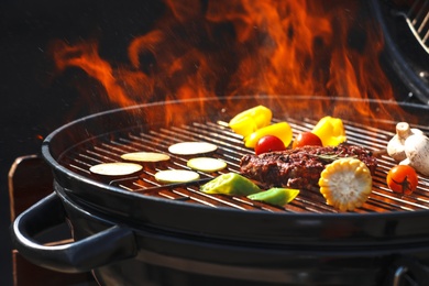 Photo of Tasty steak and vegetables on burning barbecue grill, closeup
