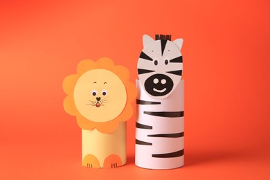 Toy lion and zebra made from toilet paper hubs on orange background. Children's handmade ideas